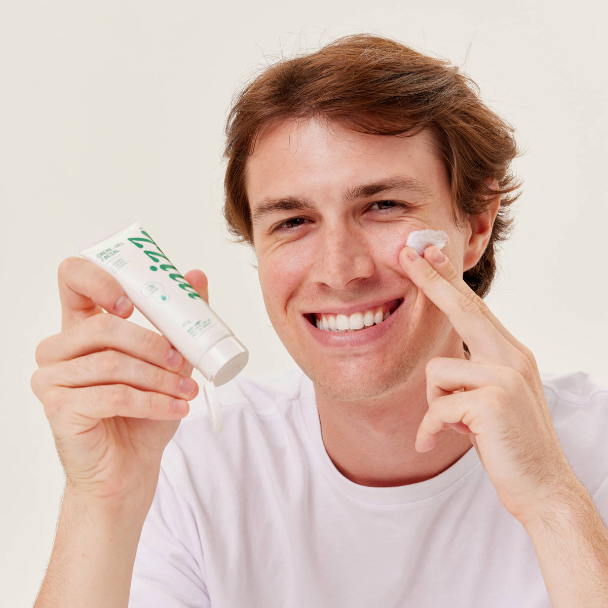Homem sorridente aplica Creme-gel Facial Hidratante 72h Mizz na bochecha